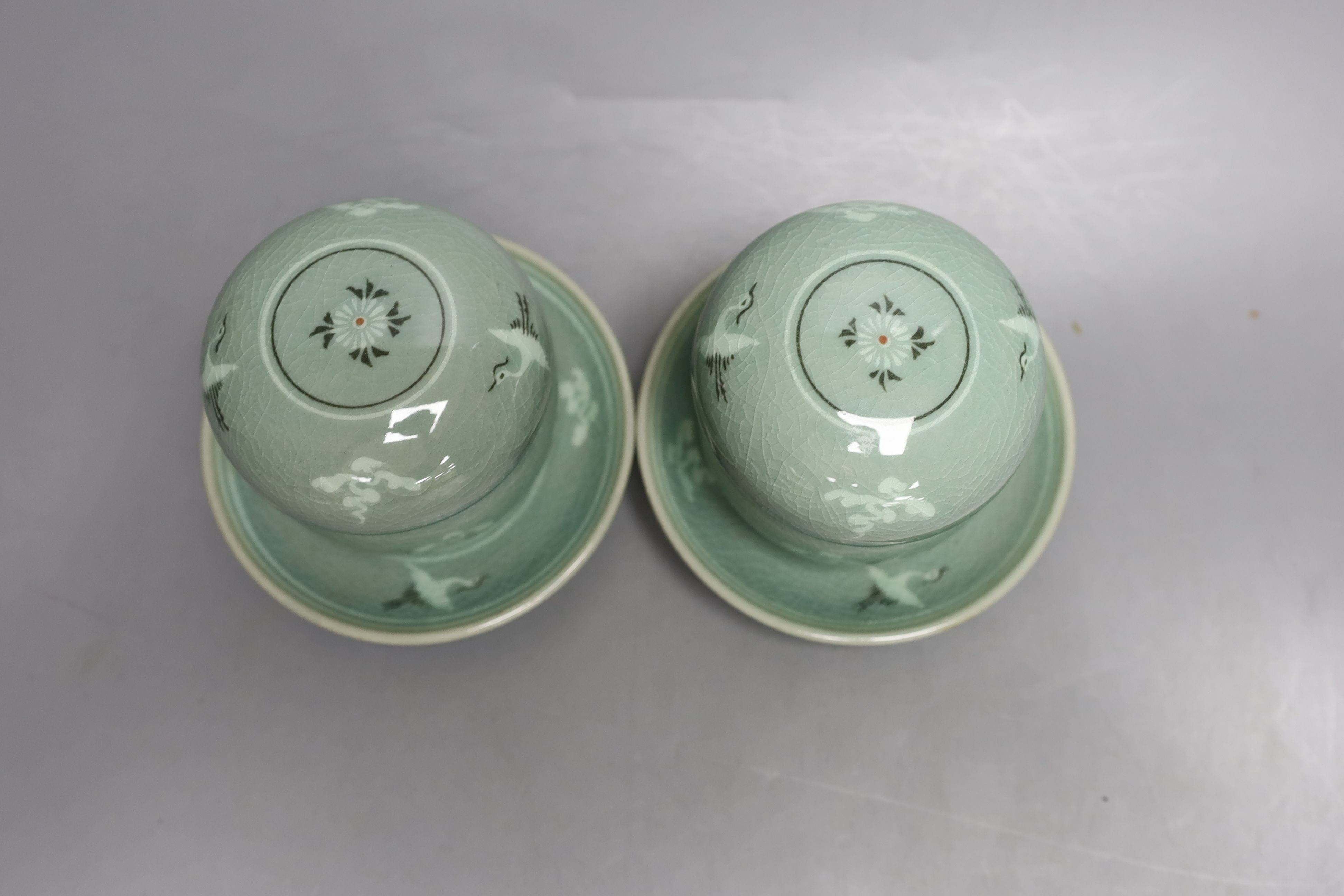 A pair of Korean green glazed pottery tea bowls, cover and stand with strainer each inside - 11cm tall